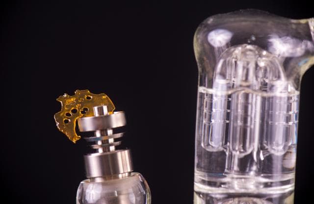 Dab rig with a piece of cannabis concentrate on the banger