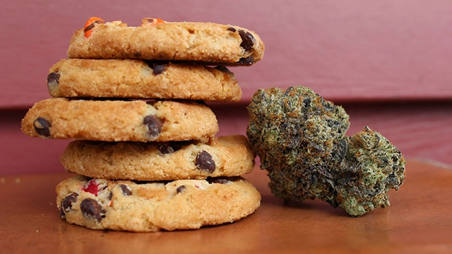 An assortment of baked edibles alongside cannabis buds, illustrating the variety of edibles derived from different cannabis strains.