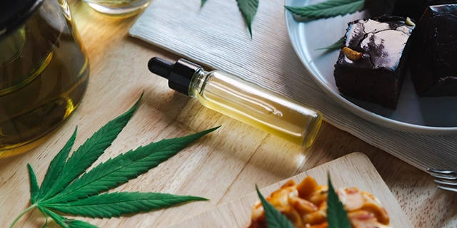 Various ingredients for creating cannabis tinctures laid out next to dropper bottles, illustrating the preparation process of THC tinctures.