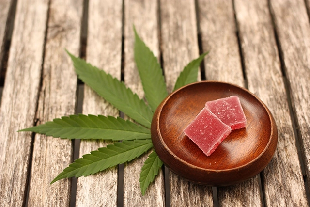 Indica-infused gummy edibles on a rustic wooden surface, indicating a relaxing and soothing effect suitable for consumers seeking a calming experience.