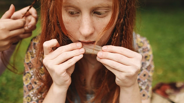 A person in the process of rolling a joint, demonstrating the art of rolling for a beginner tutorial.