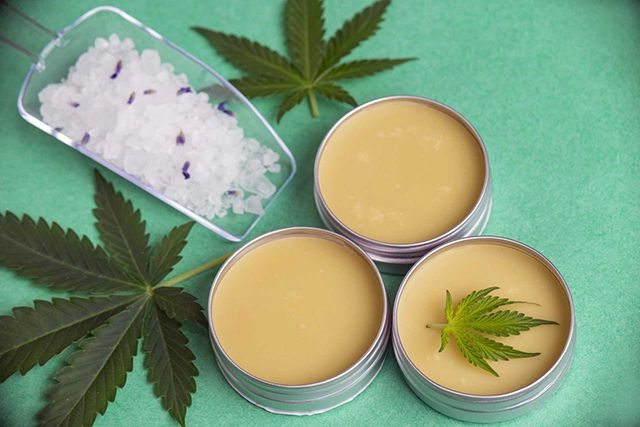 A selection of topical CBD creams and balms, with a focus on a jar in the foreground, all outlined in blue, showcasing the external application forms of CBD for therapeutic use.
