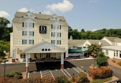 Aerial view of a hotel with a white exterior and ample parking