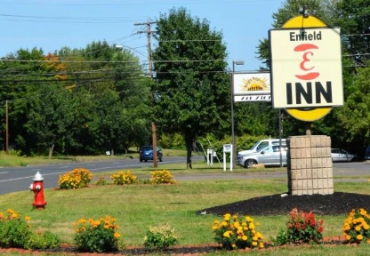A welcoming sign for the Enfield Inn with a floral display, indicating a comfortable and inviting accommodation.